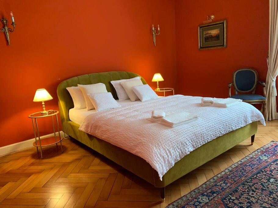 a bedroom with a large bed with orange walls at dolce vita in Biasca