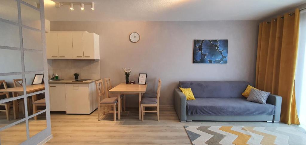 Il comprend un salon avec un canapé bleu et une cuisine. dans l'établissement Seven days, 2 pokoje, garaż w cenie, à Wrocław