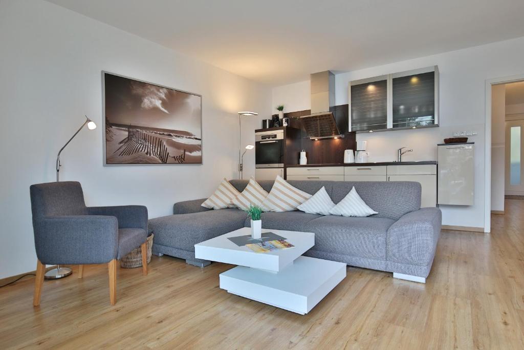 un soggiorno con divano e 2 sedie di Domizil am Meer Domizil am Meer Appartement 13 a Timmendorfer Strand