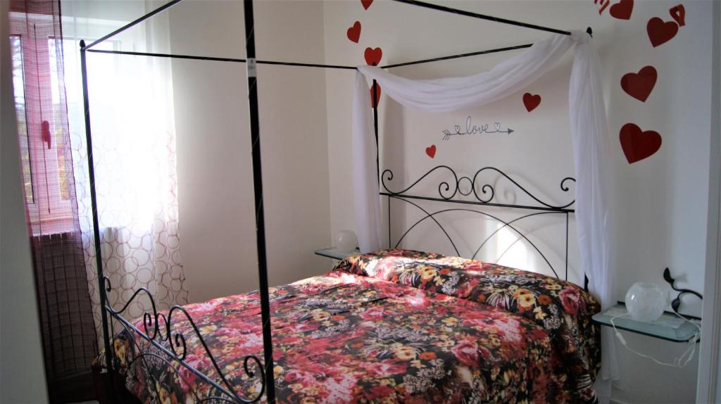 1 dormitorio con 1 cama con corazones en la pared en Arome B&B, en Santeramo in Colle