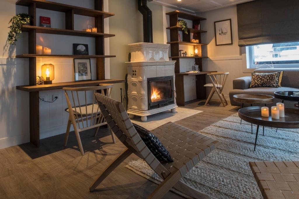 a living room with a fireplace and a couch at Chalet hôtel le Whymper in Chamonix