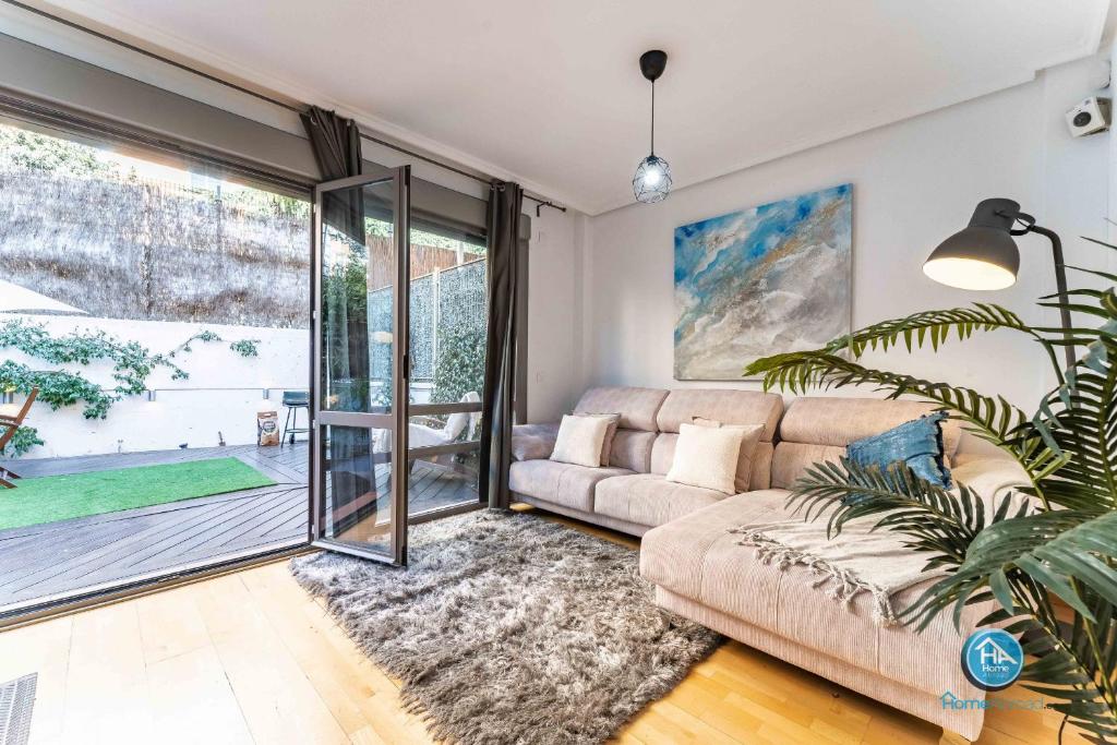 a living room with a couch and a sliding glass door at Super Deluxe Villa with FREE Parking Madrid Center in Madrid