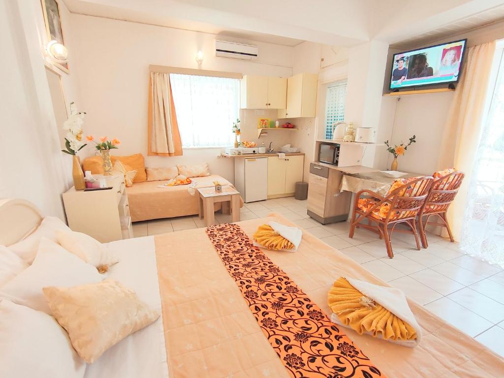 a living room with a couch and a kitchen at Evli Apartments in Rethymno Town