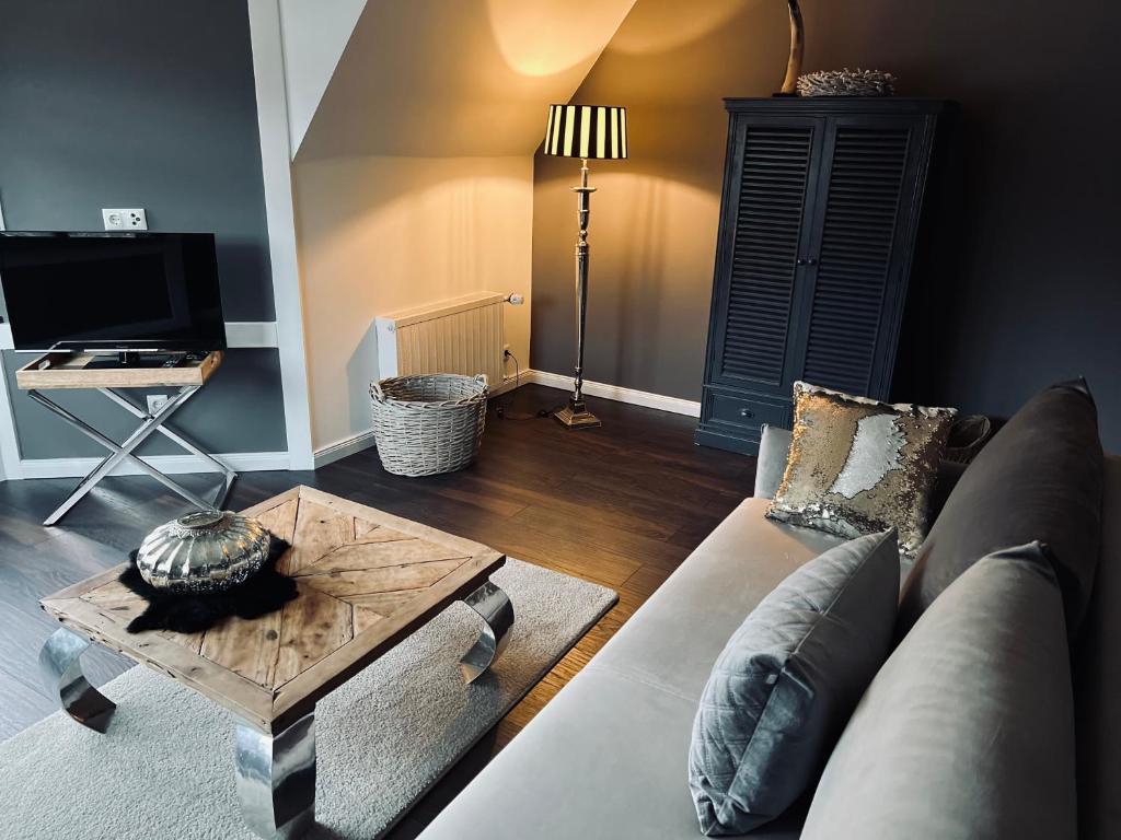 ein Wohnzimmer mit einem Sofa und einem Couchtisch in der Unterkunft Ring Residenz by E&P Concept in Adenau