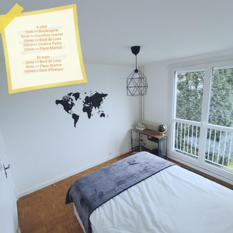 a bedroom with a bed and a world map on the wall at Chambre Monde Tout confort Saint-Marceau in Orléans