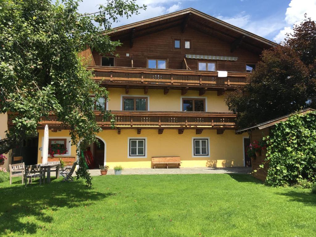 a large house with a bench in the yard at Appartement Imbachhorn in Zell am See