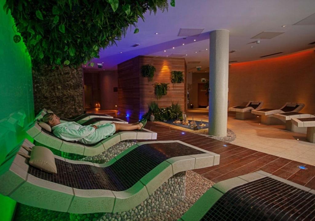 una persona che giace in un letto in una camera d'albergo di The Kingsley Hotel a Cork