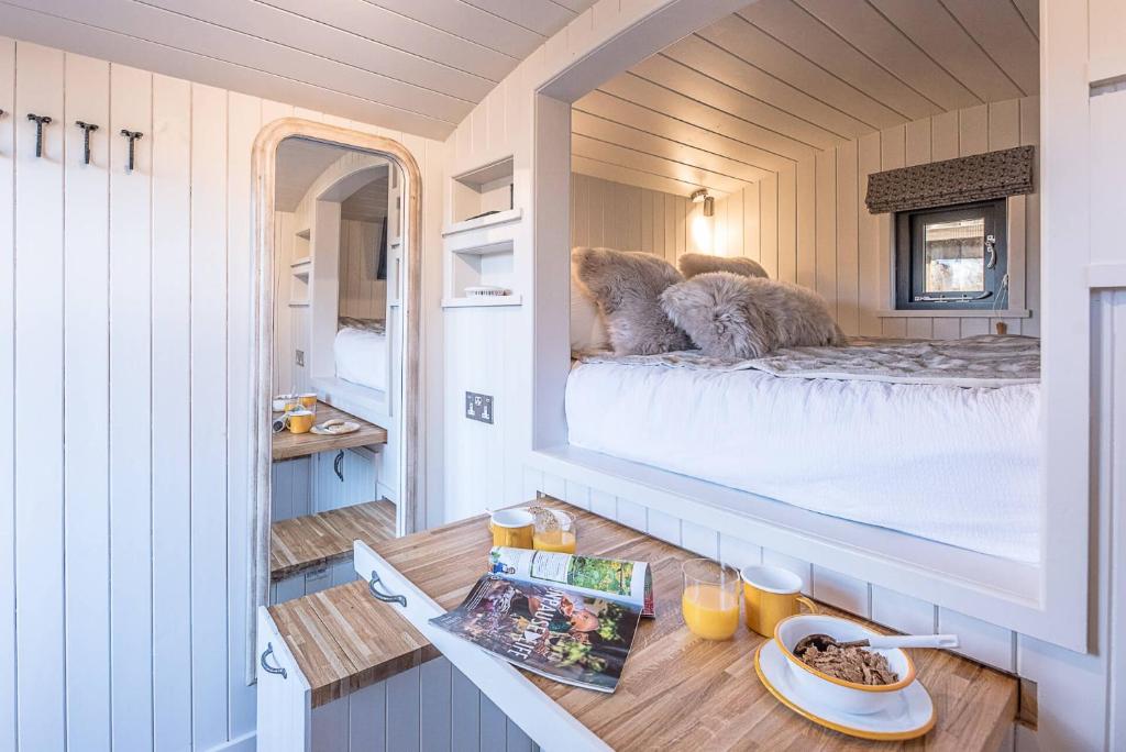 a small room with a bed in a tiny house at Bo Peep Shepherds Hut Thorpeness Air Manage Suffolk in Leiston