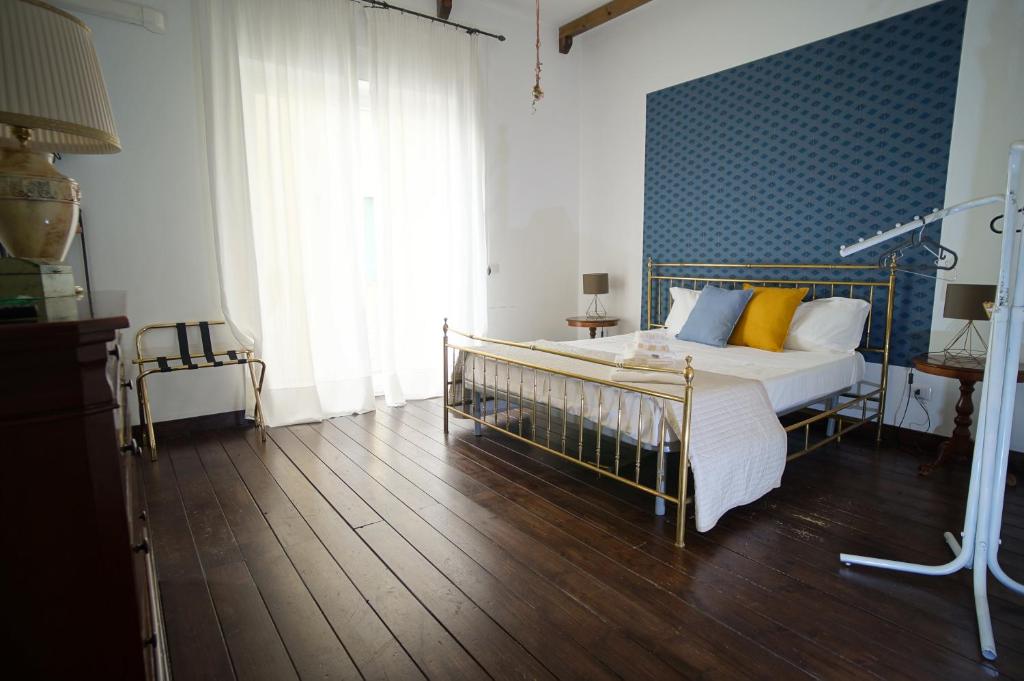 una camera da letto con letto con cuscini gialli e parete blu di Cittadella Rooms a Salerno