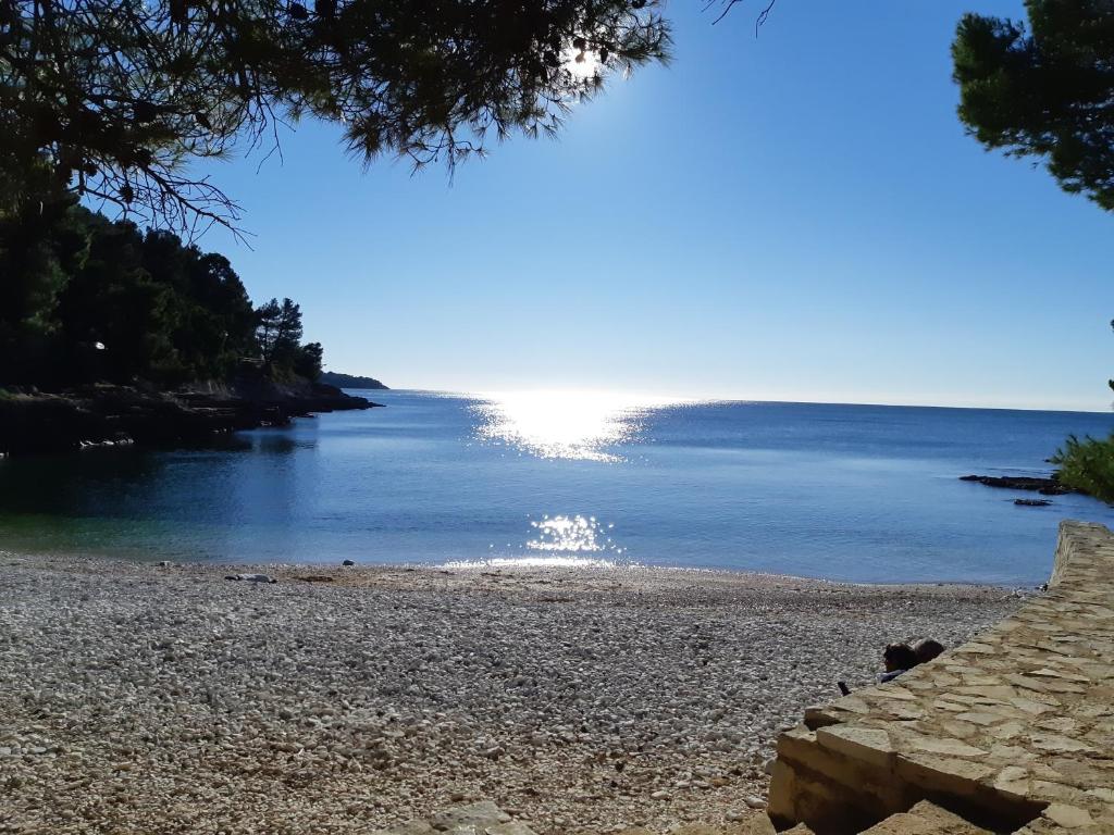 a beach with the sun reflecting in the water at Apartman Diana,free parking in Pula