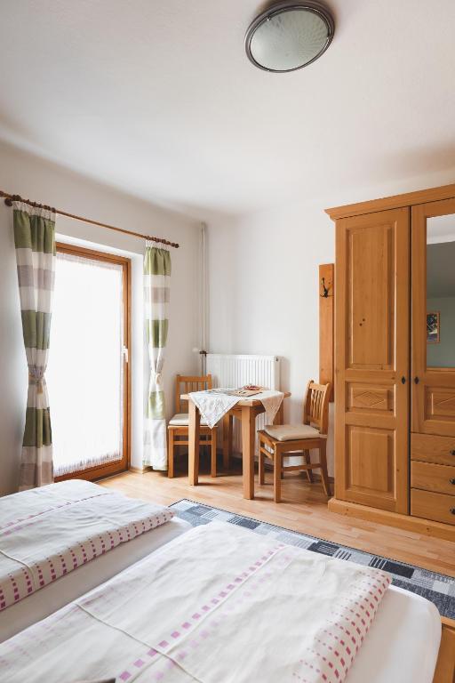 een slaapkamer met een bed, een tafel en een raam bij Weingut Peter Grill in Leutschach