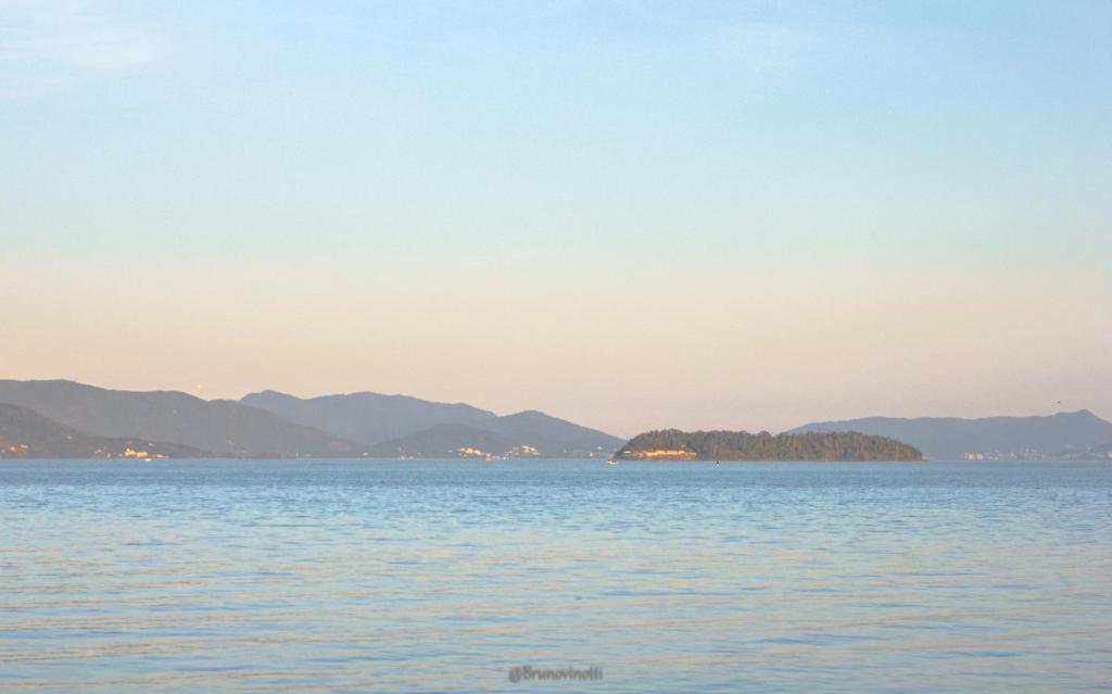a large body of water with mountains in the background at Pousada Casa do Oscar in Governador Celso Ramos