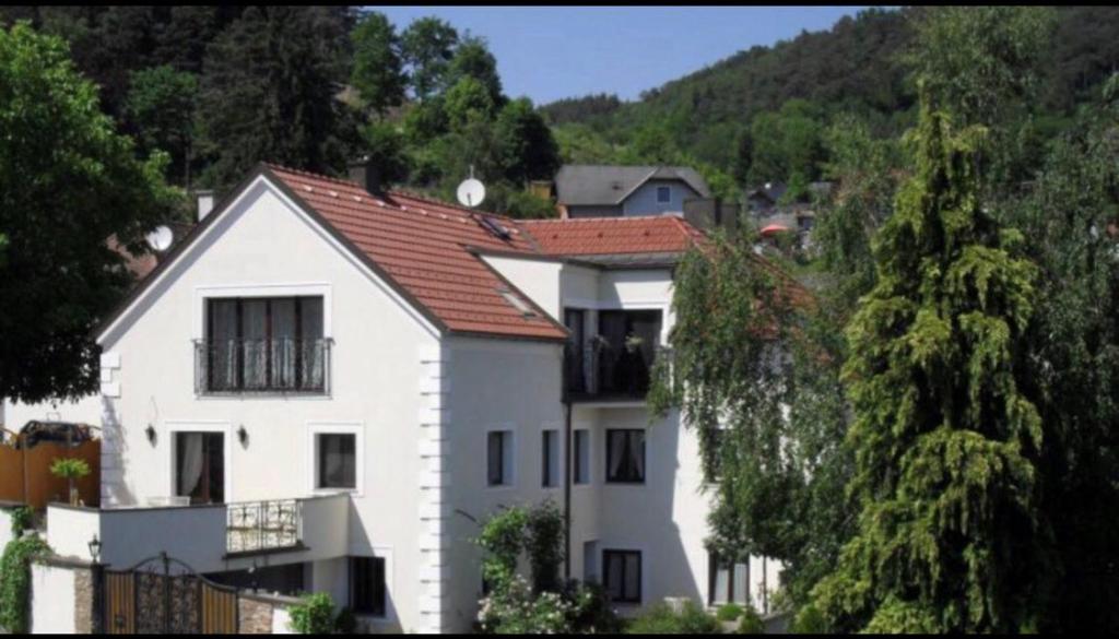 uma casa branca com um telhado vermelho numa colina em Pension Artstetten em Artstetten