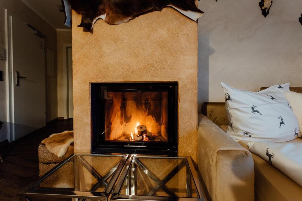 a fireplace in a living room with a couch at Residenz JANET by MoniCare in Seefeld in Tirol