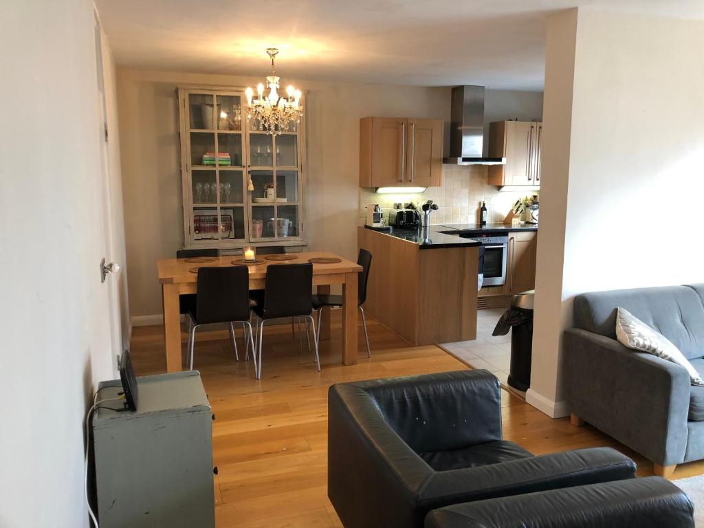 eine Küche und ein Wohnzimmer mit einem Tisch und Stühlen in der Unterkunft Notting Hill Apartment in London