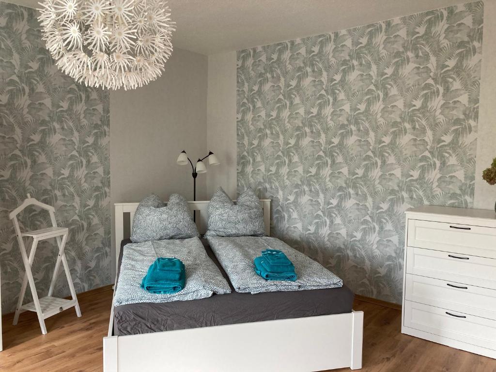 Schlafzimmer mit einem Bett und einem Kronleuchter in der Unterkunft Schöne Zweiraumwohnung in Cottbus in Cottbus