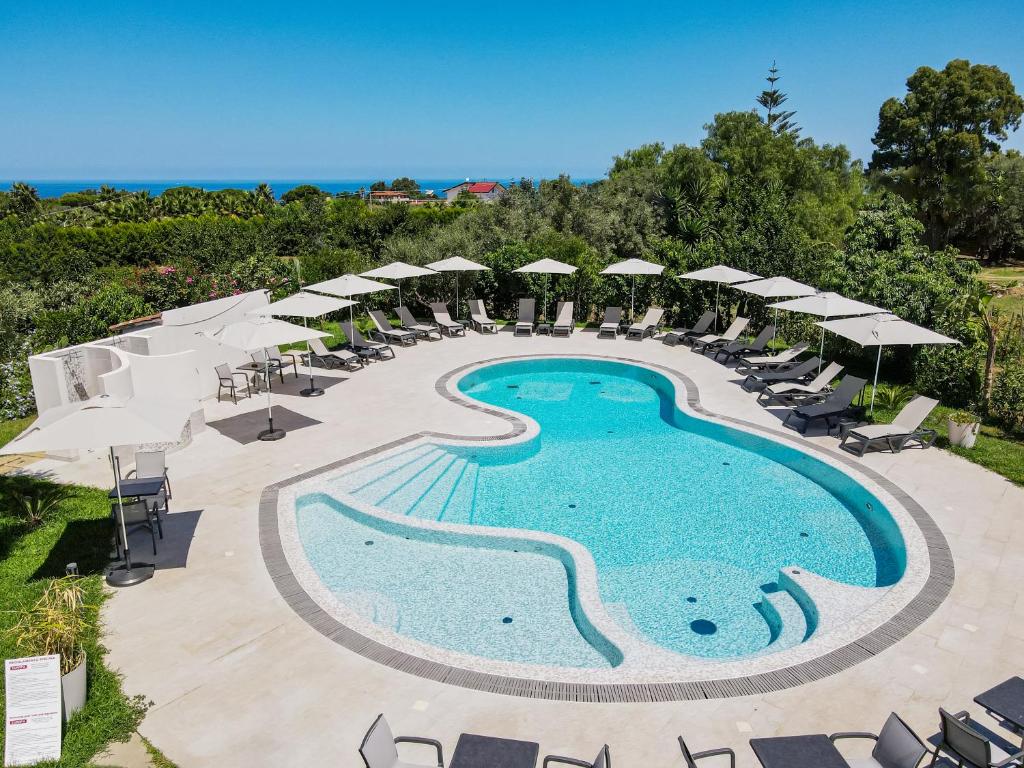 una piscina al aire libre con sombrillas y sillas en Europa rooms and restaurant en Capo Vaticano