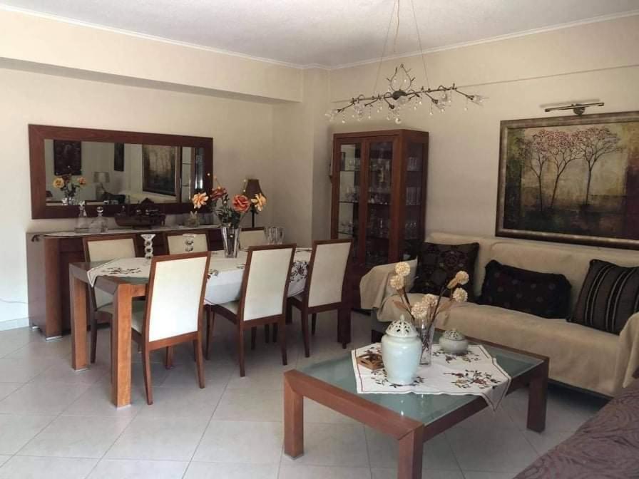 uma sala de estar com um sofá e uma mesa com cadeiras em Sweet luxury apartment Peraia em Perea