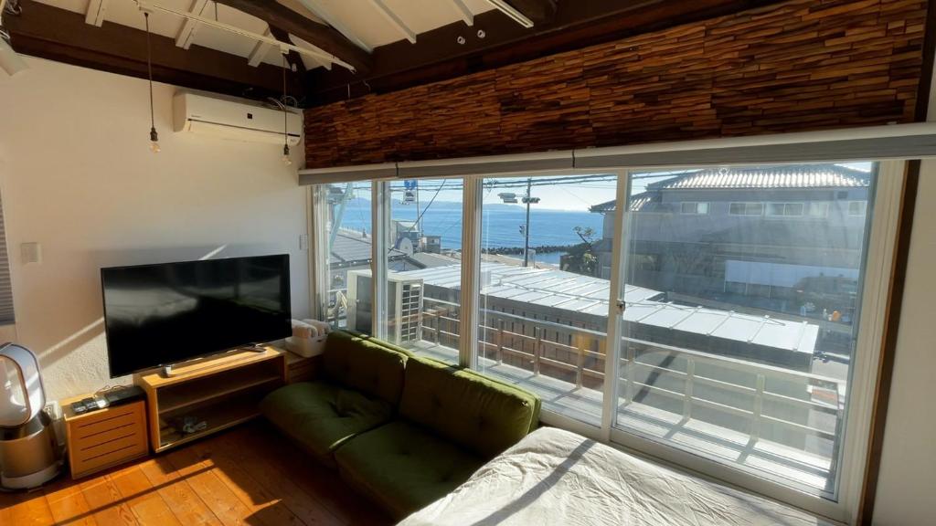 uma sala de estar com um sofá e uma grande janela em SHONAN garden - Vacation STAY 15108v em Kamakura