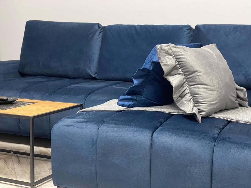 a blue couch with a pillow on top of it at Apartament Elisabeth BLUE I in Pogórze
