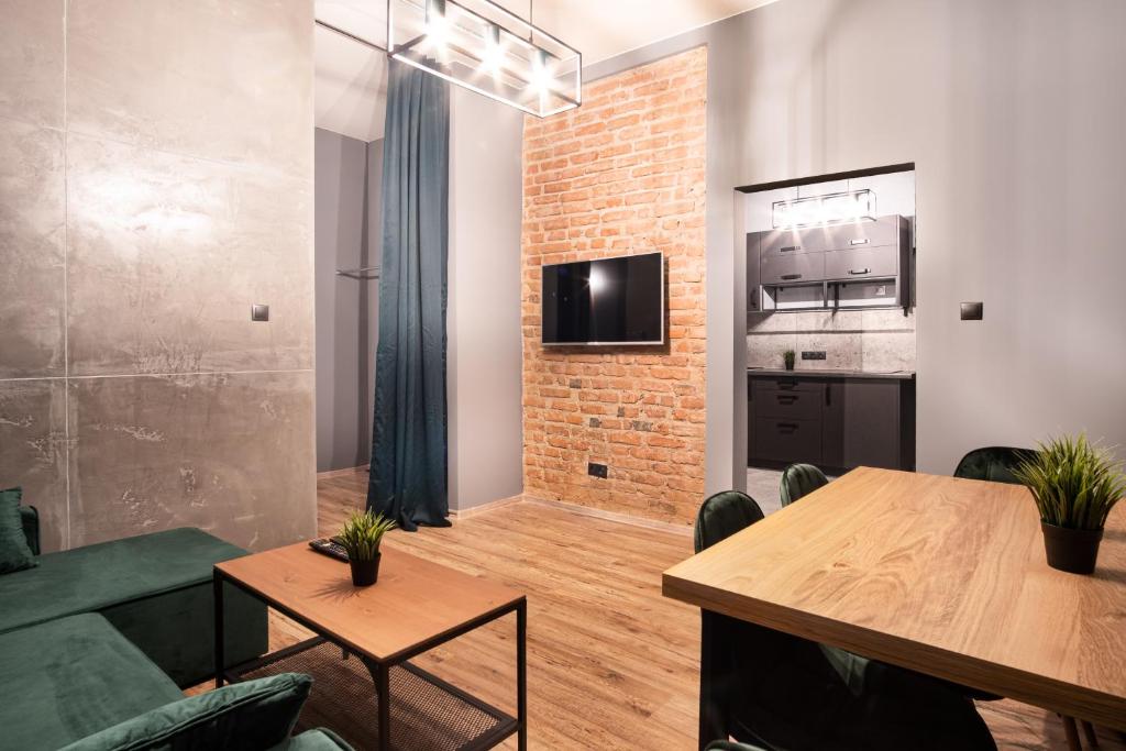uma sala de estar com um sofá verde e uma mesa em Revolution Aparts - Studio em Lódź