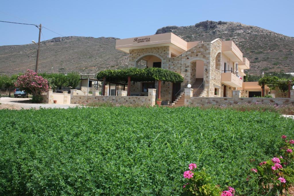 a house with a mountain in the background at Romantica Apartments in Falasarna