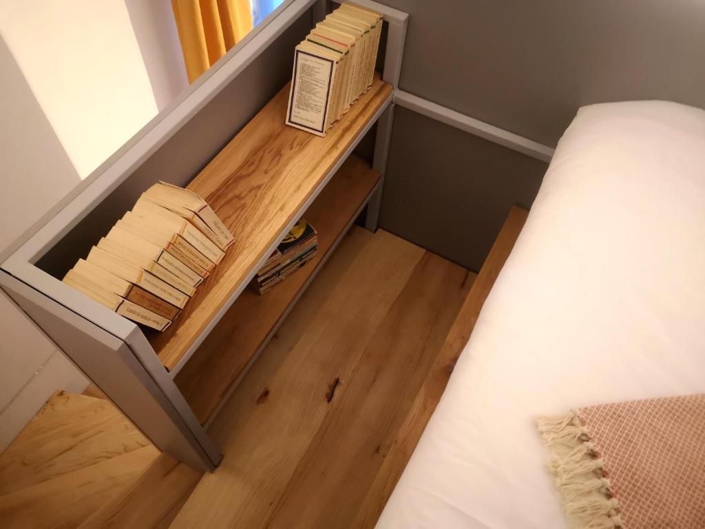 um pequeno quarto com uma cama e piso em madeira em Codicei Studio em Braşov