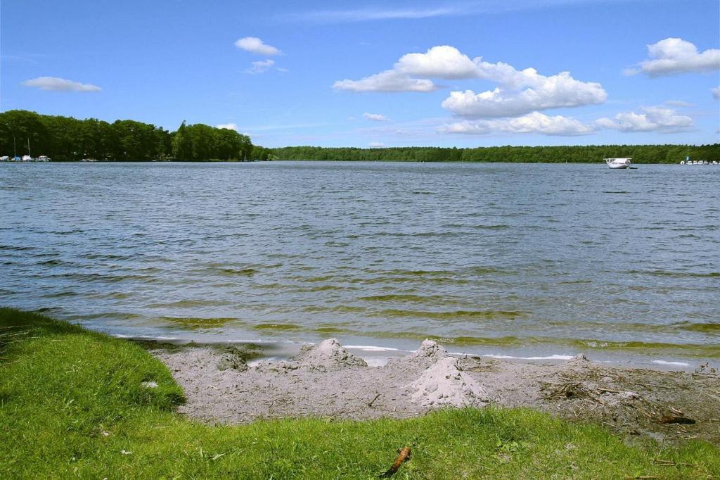 a sand castle on the shore of a lake at Bungalow Wernsdorf in Wernsdorf