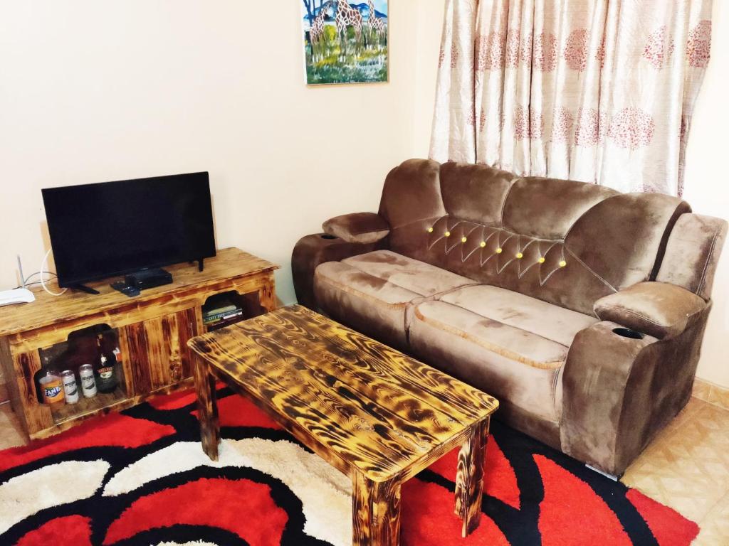 ein Wohnzimmer mit einem Sofa und einem Tisch in der Unterkunft Ella's Haven in Nairobi