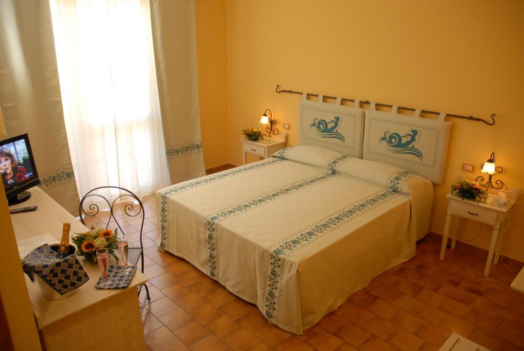 A bed or beds in a room at LE NEREIDI Hotel & Residence con Piscina-Tennis-Fitness-Parcheggio coperto-Sala Conferenze