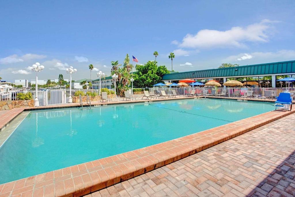 a swimming pool at a resort with a blue chair at Bay Mariner - Gorgeous Water Front Condo! in Sarasota