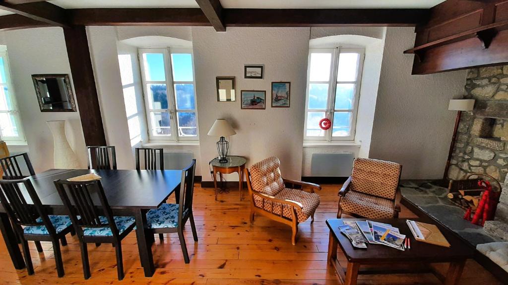 sala de estar con mesa de comedor y sillas en Gite La Coustourelle - Appartement T4 en coeur de village, en Le Chambon-sur-Lignon