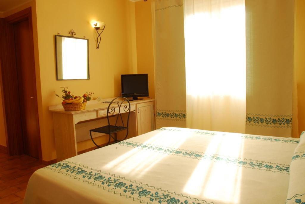 A bed or beds in a room at LE NEREIDI Hotel & Residence con Piscina-Tennis-Fitness-Parcheggio coperto-Sala Conferenze