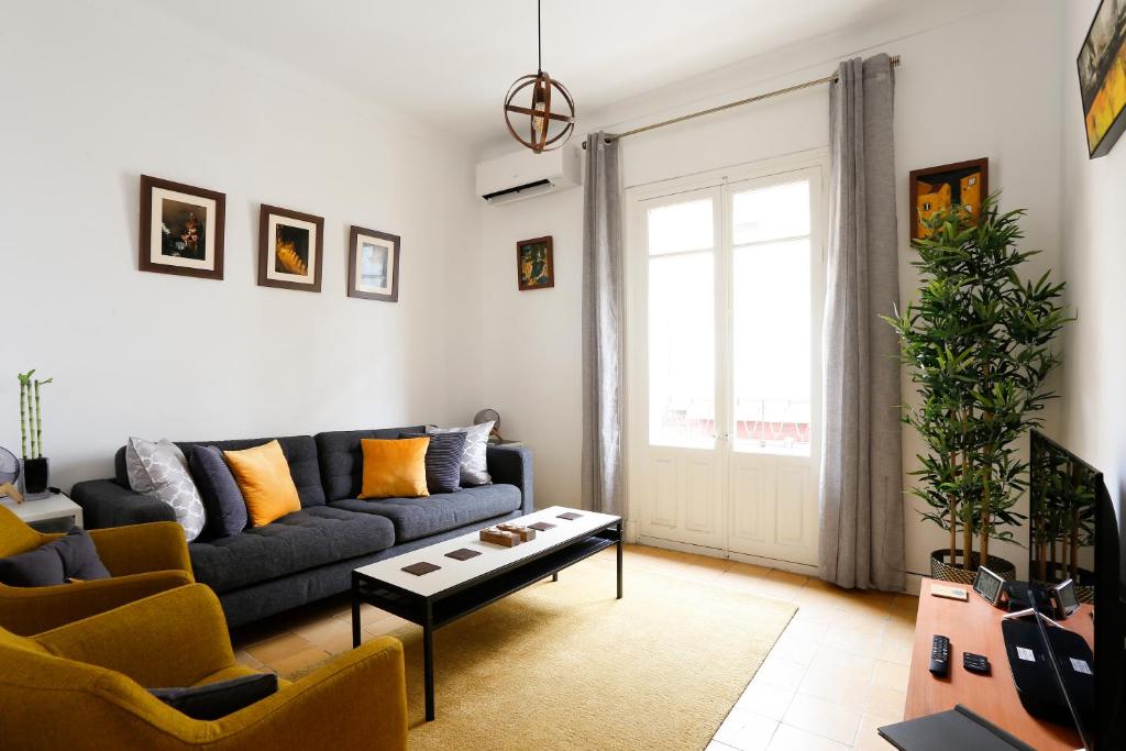 - un salon avec un canapé et une table dans l'établissement Bonito Apartamento a un paso del centro., à Séville