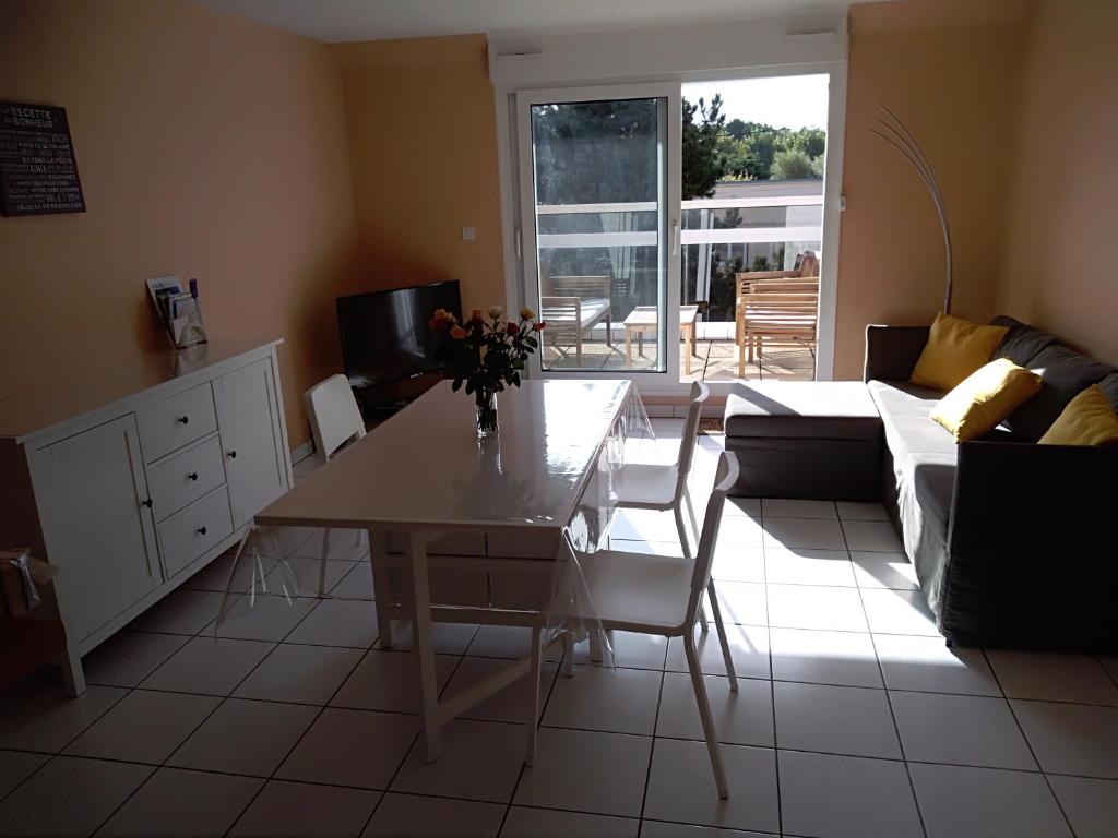 un soggiorno con tavolo e divano di Appartement ds résidence privée avec parking privé a Berck-sur-Mer