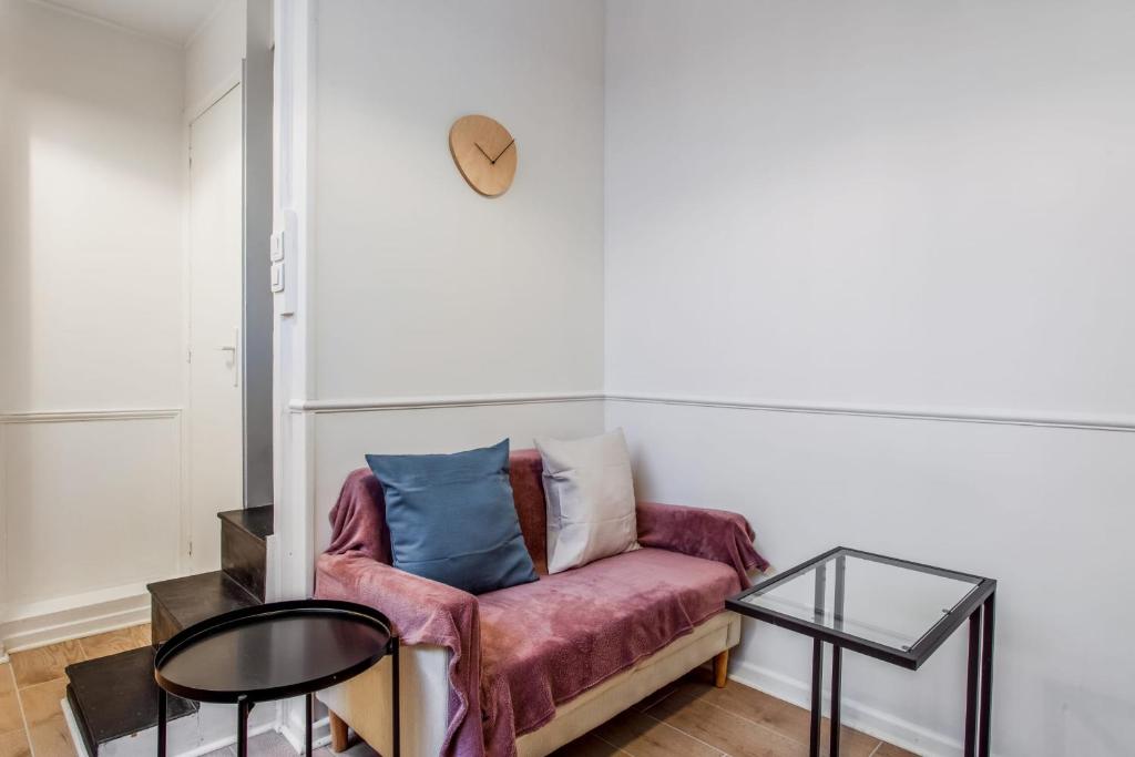 un salon avec un canapé et une table dans l'établissement Appartement des Bergères - Welkeys, à Paris