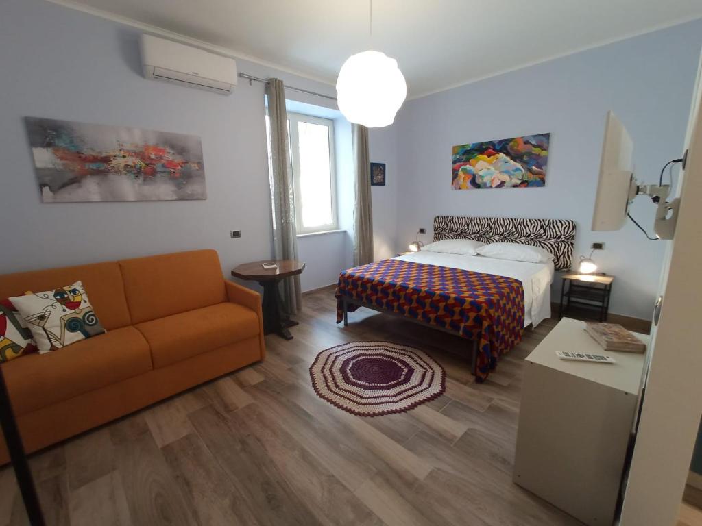 ein Wohnzimmer mit einem Bett und einem Sofa in der Unterkunft Cappuccini Express House in Pozzuoli