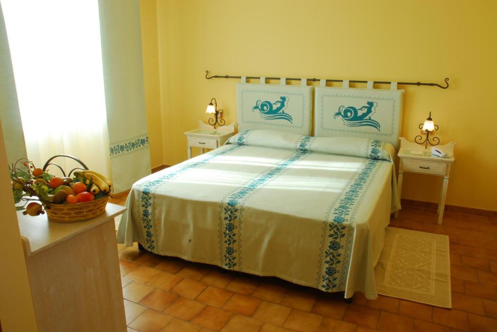 A bed or beds in a room at LE NEREIDI Hotel & Residence con Piscina-Tennis-Fitness-Parcheggio coperto-Sala Conferenze