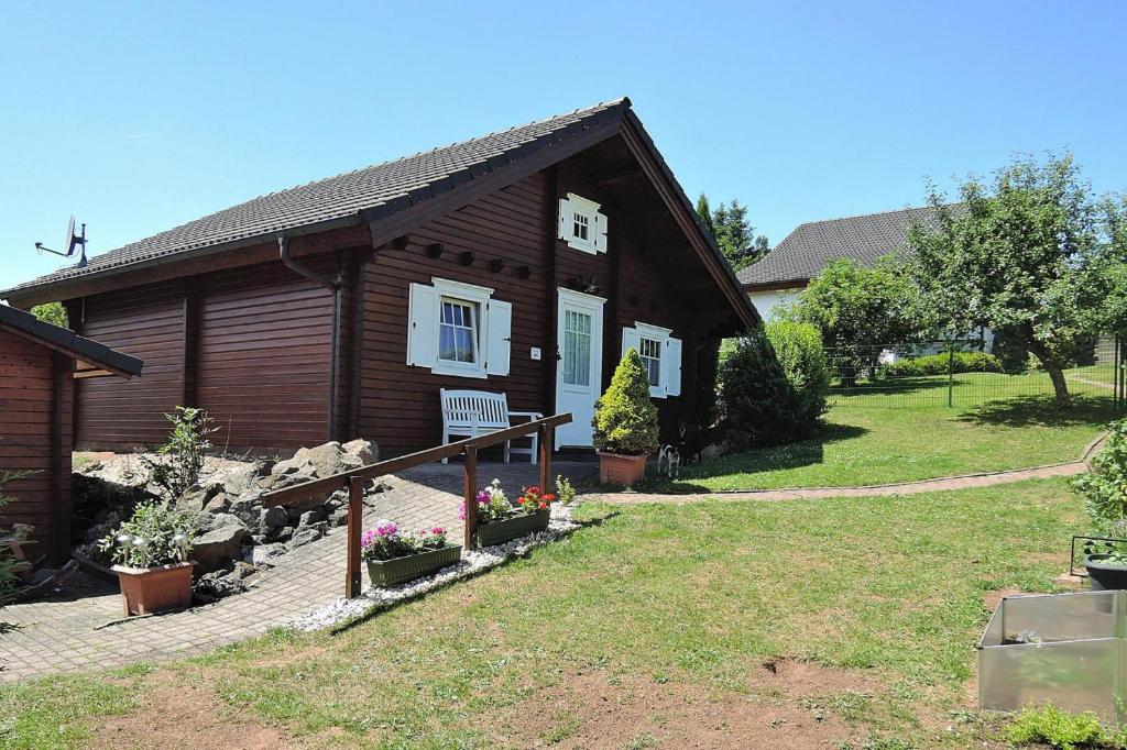 a log cabin with a yard and a house at Cottage, Lissendorf in Lissendorf