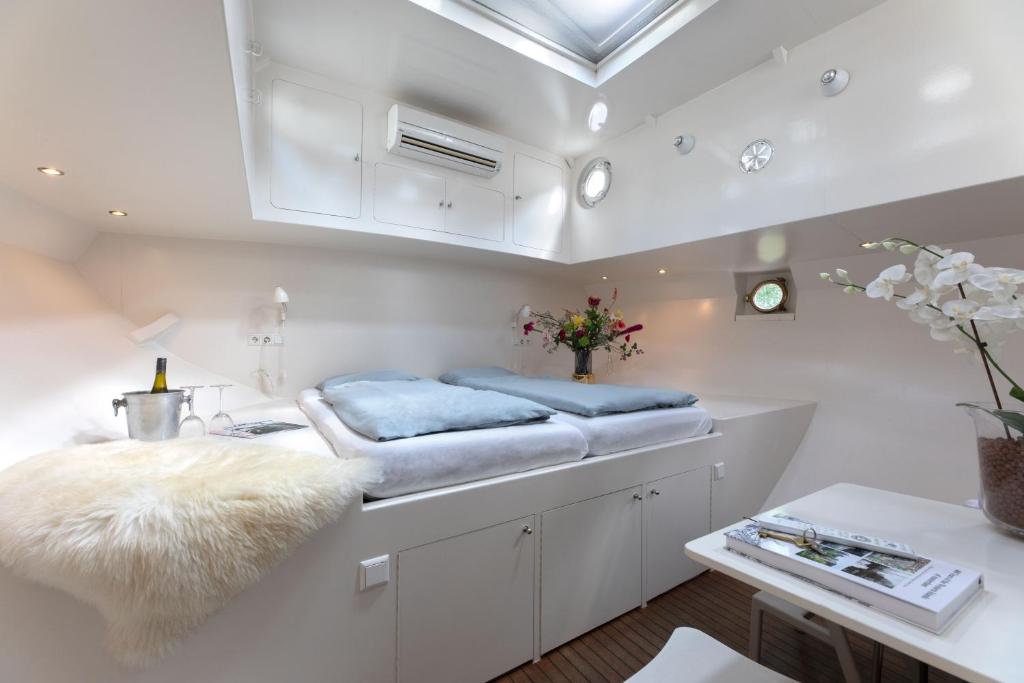 a room with white cabinets and a bench with blue cushions at Houseboat Volle Maan in Amsterdam