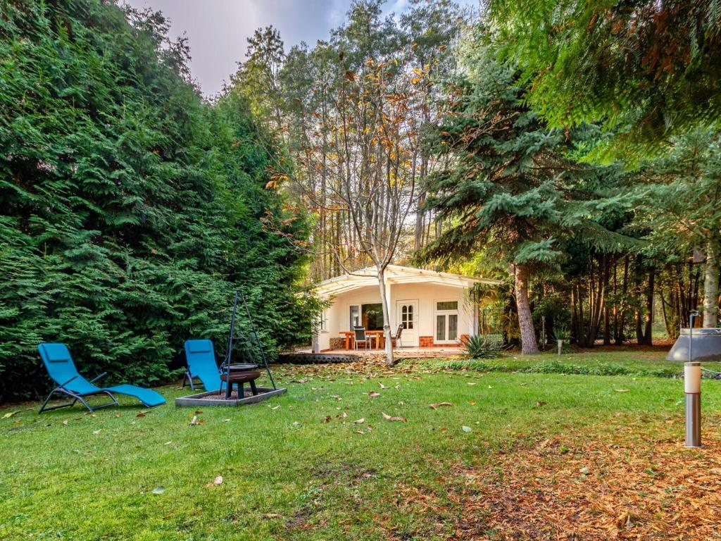 ein Haus mit zwei Stühlen und einem Tisch im Hof in der Unterkunft Holiday home Fischerhaus, Parchim in Parchim