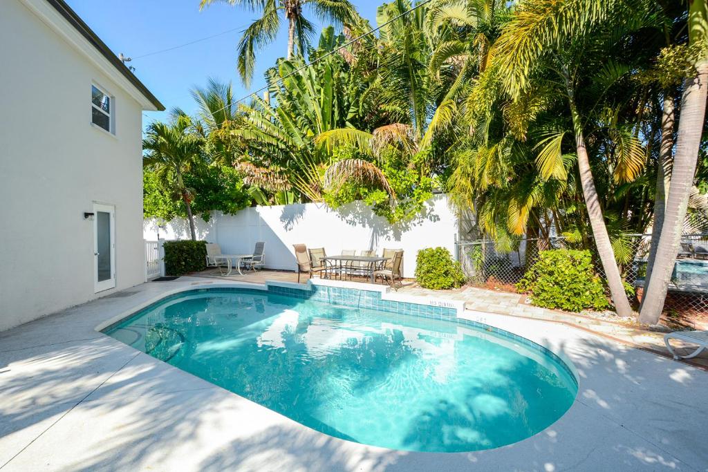 a swimming pool in front of a house with palm trees at Canal 315 - Right in Siesta Key Village! in Siesta Key