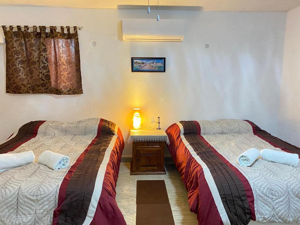 Zimmer mit 2 Betten und einem Tisch in der Unterkunft Casa Liz in Cozumel