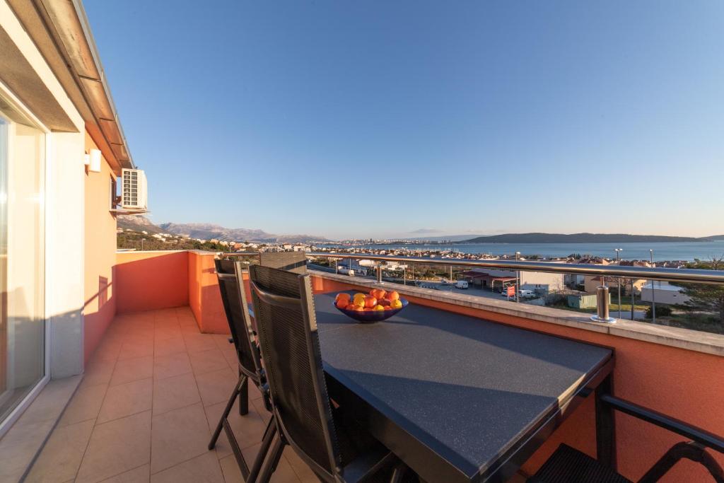 a table on a balcony with a view of the ocean at Apartments Katarina in Kaštela