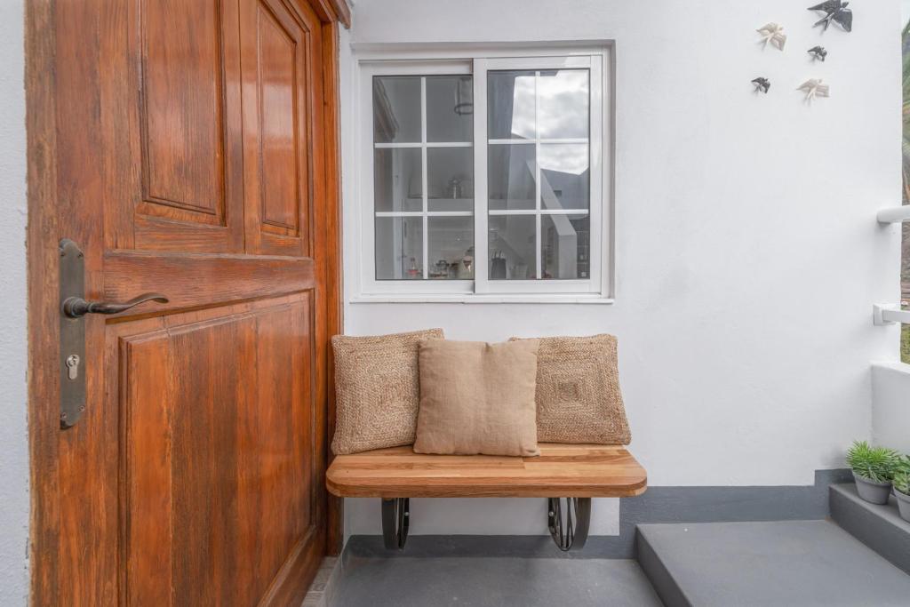 a bench with two pillows sitting next to a door at Apartamento La Alameda, Valle Gran Rey, La Gomera in Valle Gran Rey