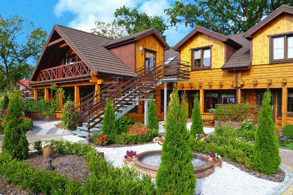 a log house with a garden in front of it at Holiday resort, Ustronie Morskie in Ustronie Morskie