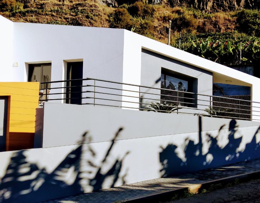 Biały dom z cieniami na ścianie w obiekcie Anjos's Choice w mieście Ponta do Sol