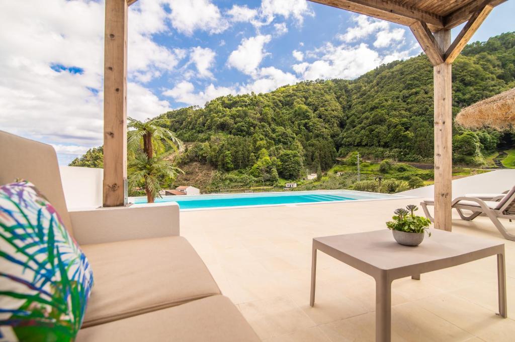 a living room with a couch and a table at Casa do Outeiro with Heated Pool 30C in Povoação