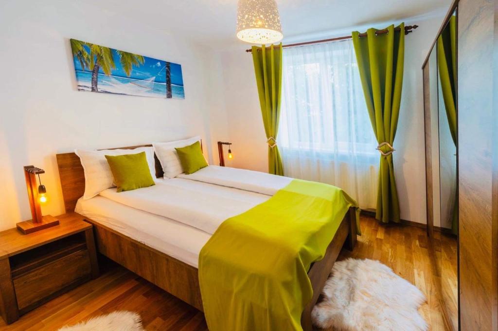 una camera da letto con un grande letto con lenzuola verdi e una finestra di Relax Apartment 1 a Sighişoara