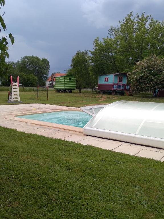 a swimming pool with a slide in the grass at Roulotte verte in Pouilly-sur-Vingeanne